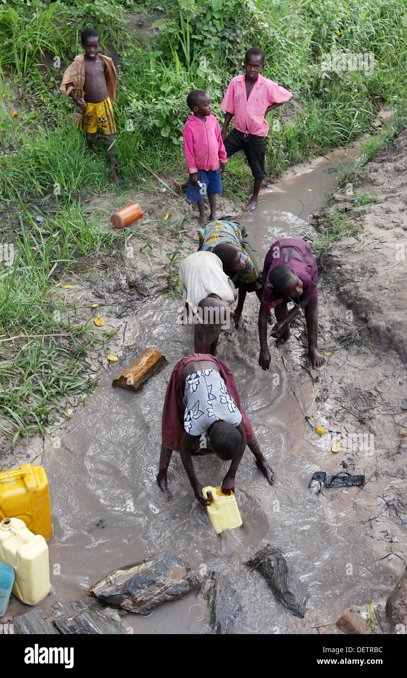 Les jeunes enfants du village de terminer leur journée de congé par la collecte de l'eau sale pour leurs familles dans le district de Lira d'Ouganda du Nord Banque D'Images