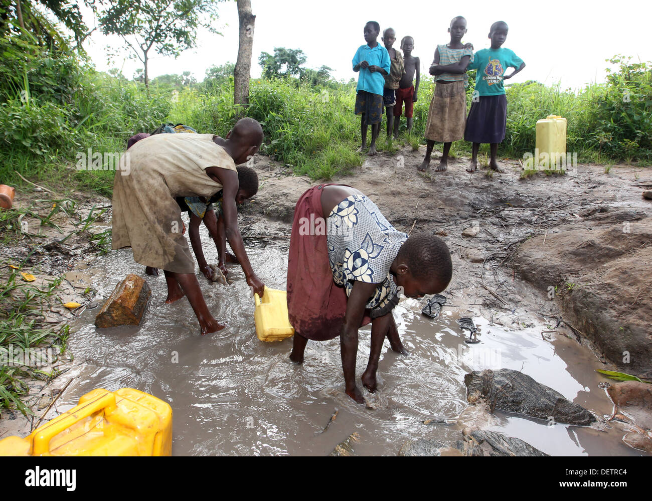 Les jeunes enfants du village de terminer leur journée de congé par la collecte de l'eau sale pour leurs familles dans le district de Lira d'Ouganda du Nord Banque D'Images