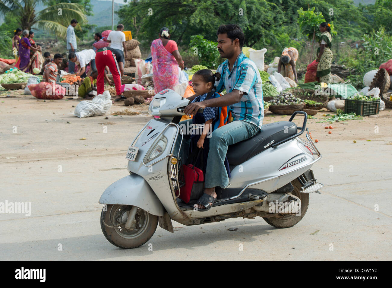 Prenant son père indien fille à l'école sur un cyclomoteur. L'Andhra Pradesh, Inde Banque D'Images