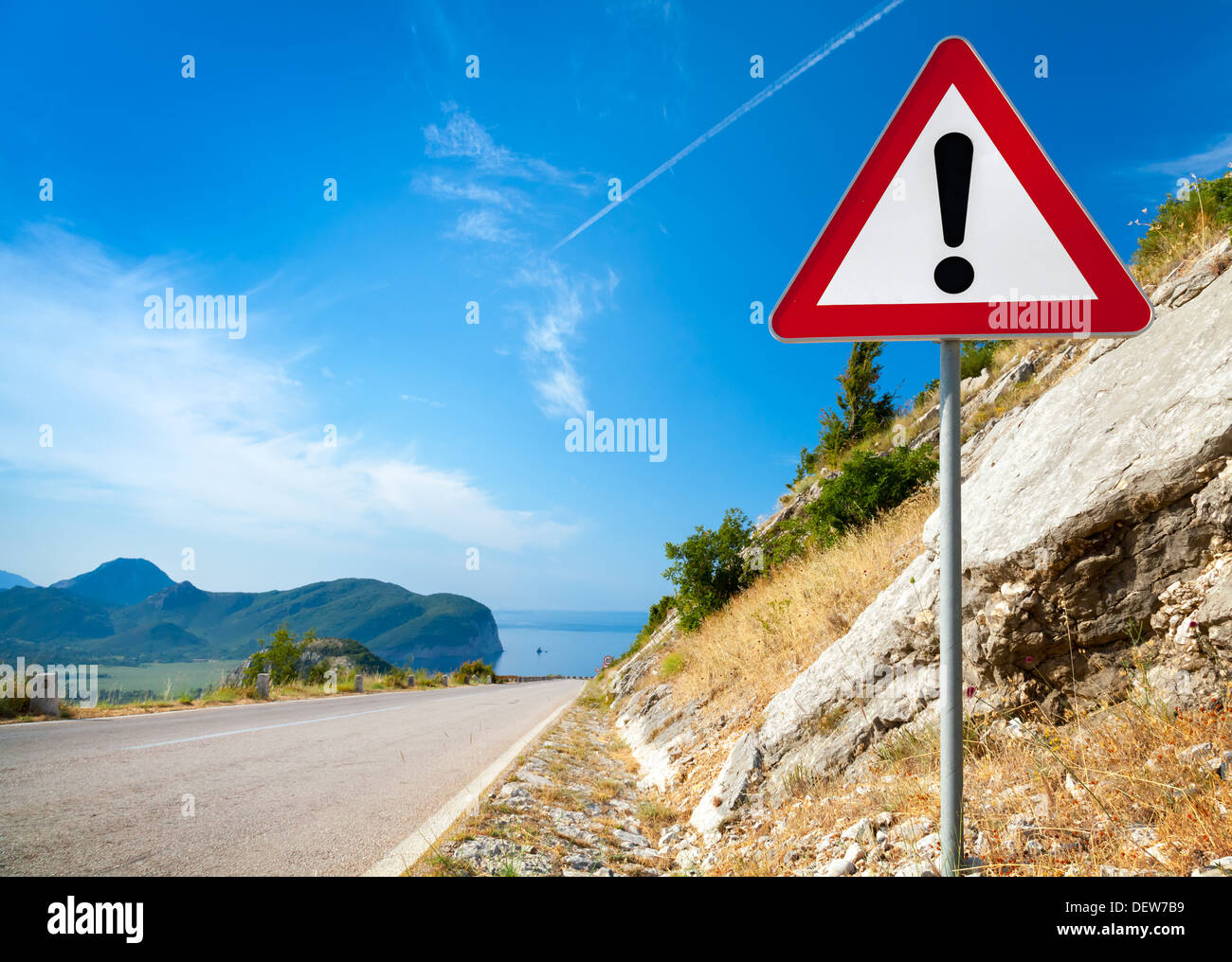 Panneau d'avertissement avec un point d'exclamation dans le triangle rouge sur route de montagne Banque D'Images