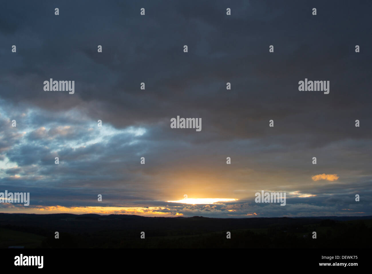 Coucher du soleil à travers les nuages orageux HORIZON SUR TERRAIN PLAT Banque D'Images