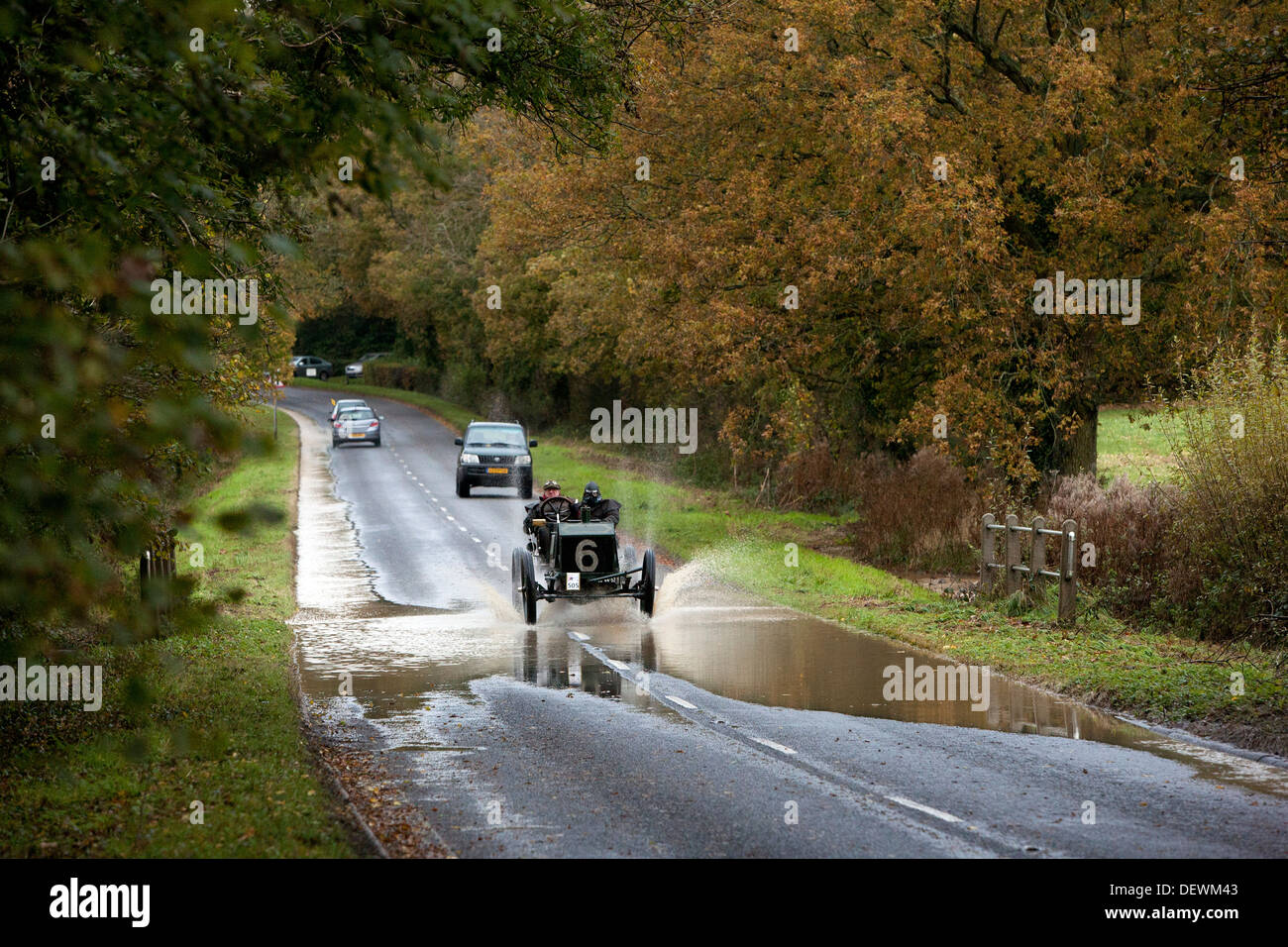 Vintage voiture roule dans une flaque d'eau sur l'ancien combattant Londres à Brighton automobile (voiture) exécuté en 2012. Les projections d'eau dans l'air. Banque D'Images