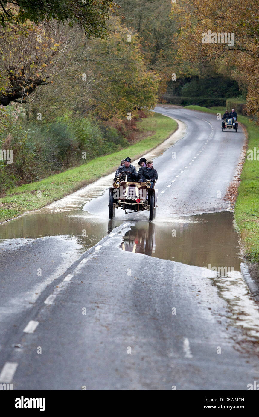 Vintage voiture roule dans une flaque d'eau sur l'ancien combattant Londres à Brighton automobile (voiture) exécuté en 2012. Les projections d'eau dans l'air. Banque D'Images