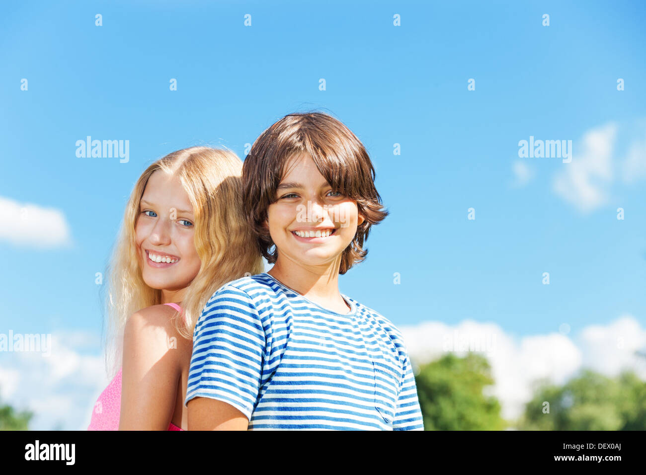 Clouse portrait of couple enfants, garçon et fille debout ensemble dans le parc, souriant aux beaux jours d'été Banque D'Images