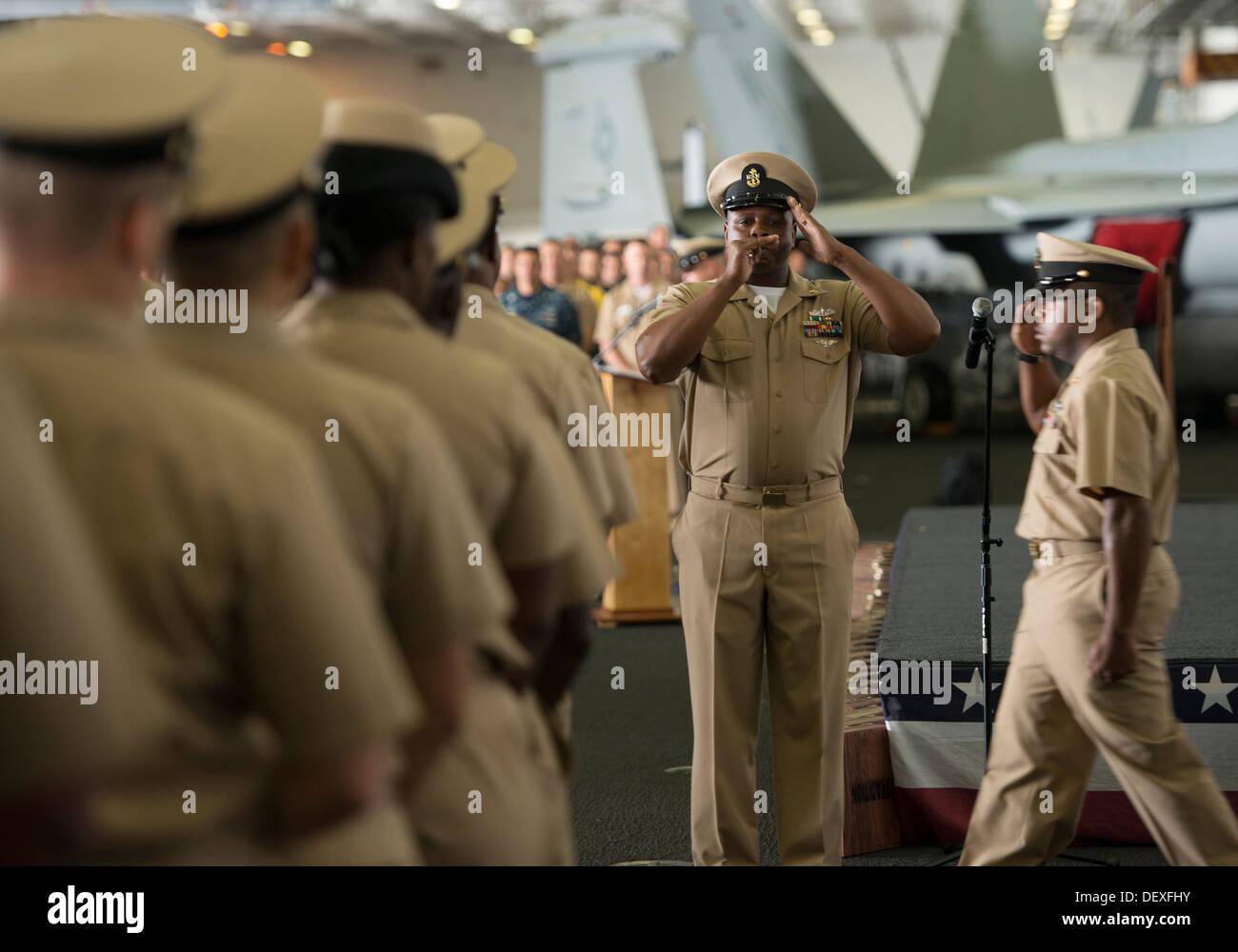 Premier maître de Manœuvre Sorrells Claiborne pipes un nouveau premier maître dans le mess des officiers en chef au cours d'une cérémonie à l'épinglage le hangar Bay à bord du porte-avions USS Carl Vinson (CVN 70). Carl Vinson est en cours la réalisation de l'unité de formation niveau off e Banque D'Images