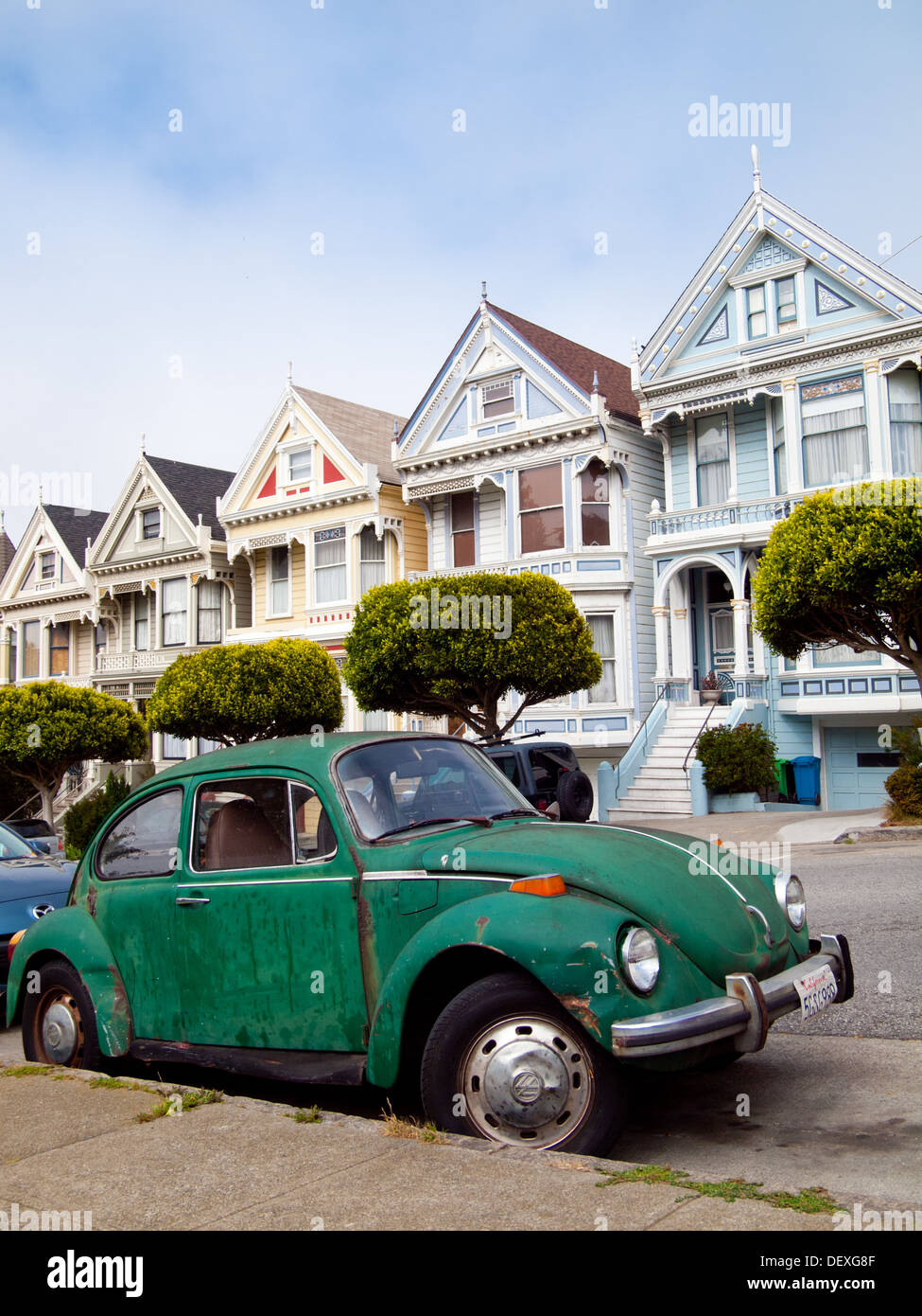 Un livre vert Volkswagen garée en face de la 'Painted Ladies' rangée de maisons victoriennes sur Steiner Street (à Alamo Square) à San Francisco. Banque D'Images