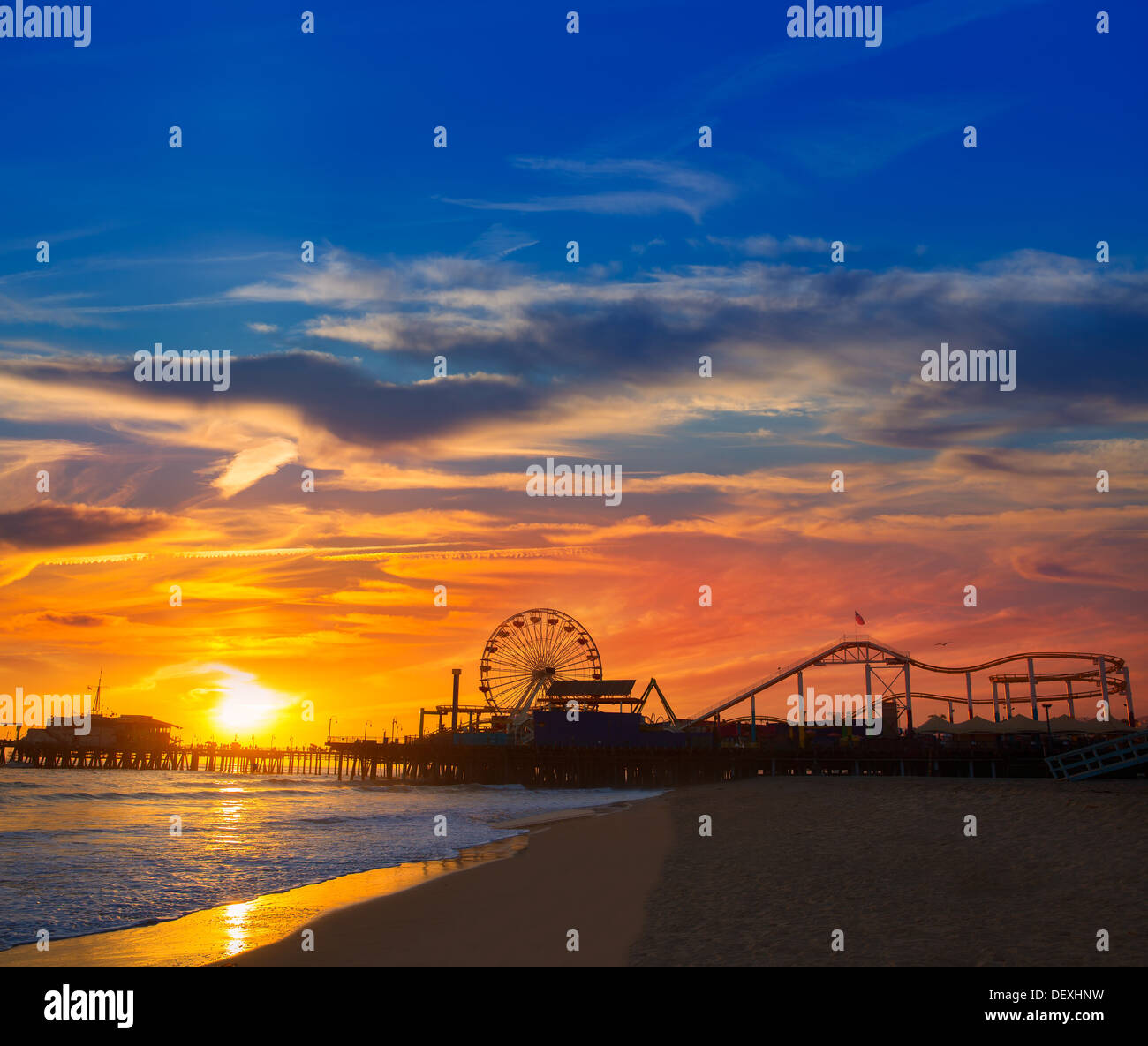 Santa Monica California Sunset sur Pier Ferrys et la réflexion sur des roues sur le sable mouillé de la plage Banque D'Images