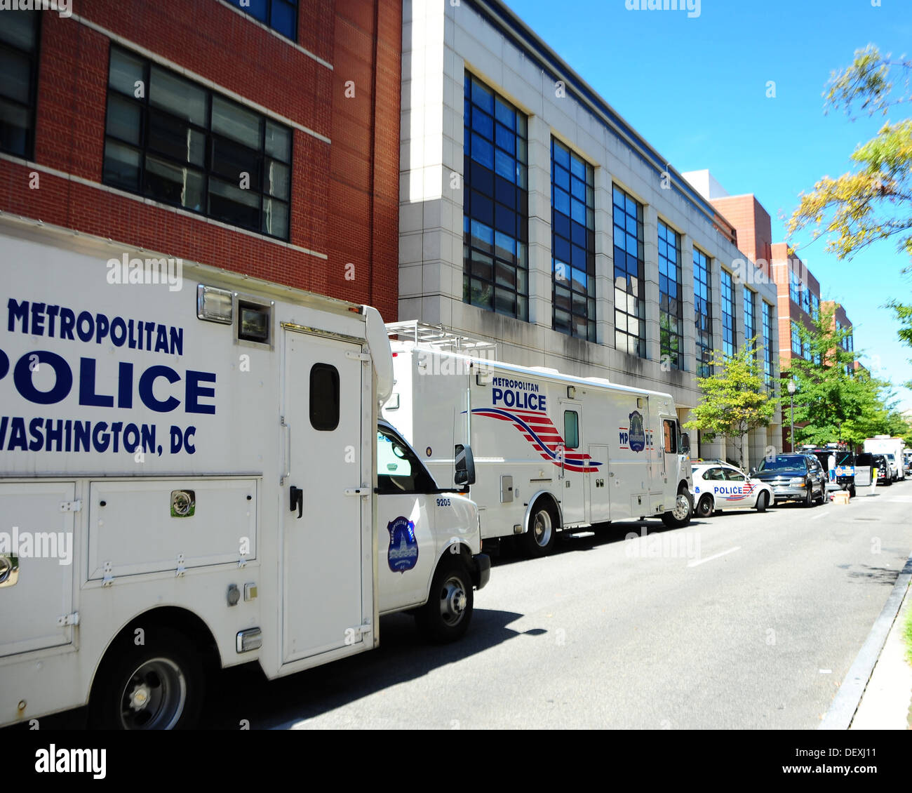 Département de la Police métropolitaine de Washington de stationnement des véhicules près du bâtiment 197 au Washington Navy Yard. La police et les équipes de collecte de preuves du FBI travaillent à la scène où un homme armé a tué 12 personnes le 16 septembre 2013. Banque D'Images