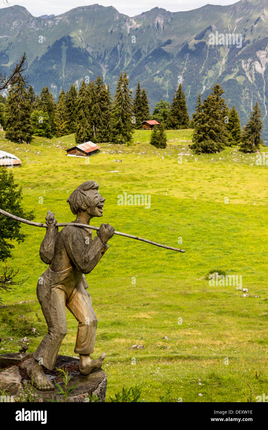 Sculpture en bois d'un garçon Randonneur sur une prairie alpine près de la Suisse, Axalp Banque D'Images