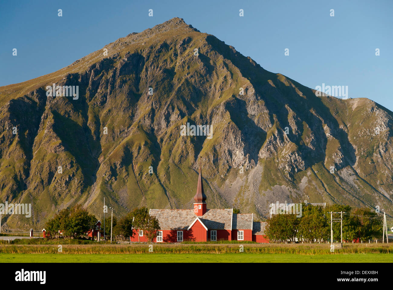 L'église de Flakstad rouge en face de montagnes abruptes, Vareid, Fredvang, île de Flakstadøya, Flakstadoya Banque D'Images