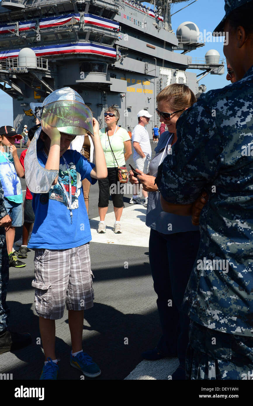 Un invité visiter le porte-avions USS Ronald Reagan (CVN 76) met un casque de pompier lors d'une démonstration par l'équipage du navire Banque D'Images