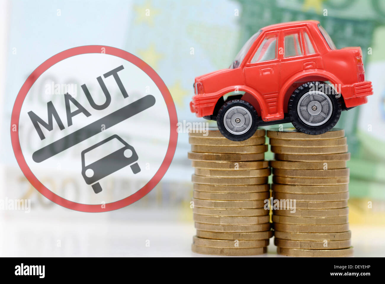 Miniature de voiture sur une pile de pièces, image symbolique pour les péages de voiture Banque D'Images