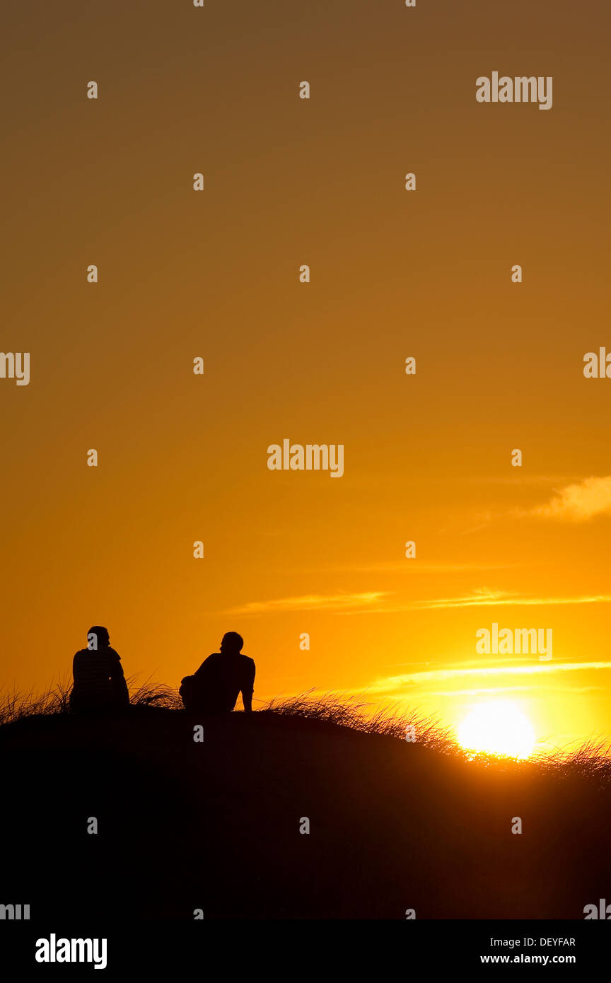 Silhouette de deux personnes dans les dunes au coucher du soleil, Nebel, Amrum, Amrum, au nord de l'archipel Frison, Schleswig-Holstein, Allemagne Banque D'Images