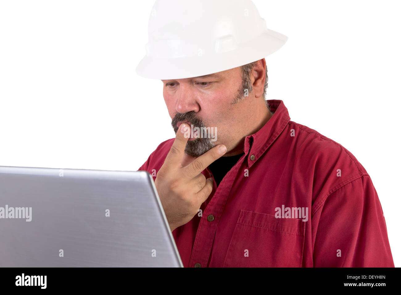 Casque de travail travailleur ou naviguer sur Internet avec son ordinateur portable, il a un regard perplexe, il porte un tee-shirt rouge et isolated on white Banque D'Images
