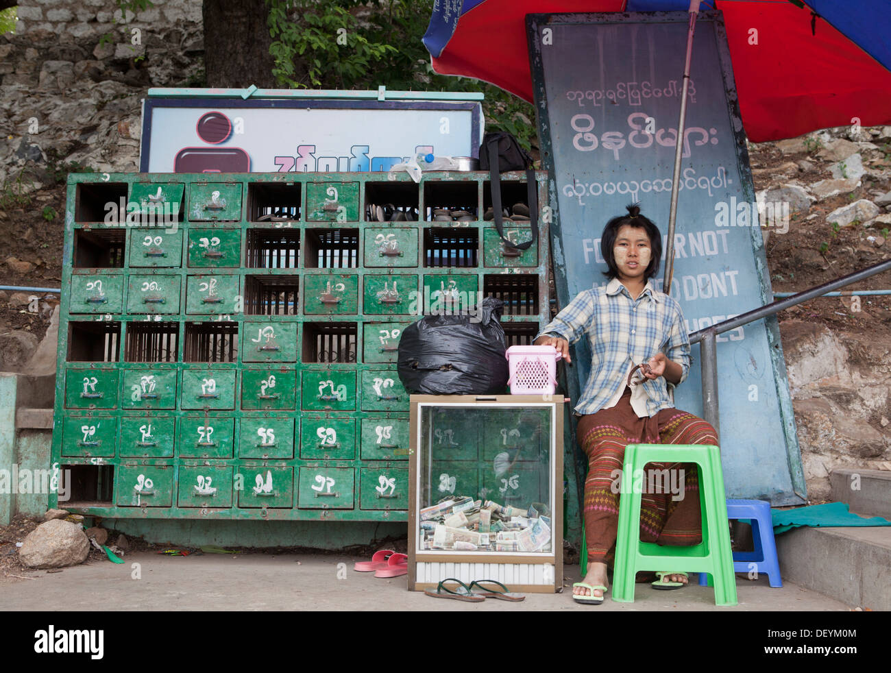 Une femme travaille dans la chaussure holding station sur Mandalay Hill. Banque D'Images