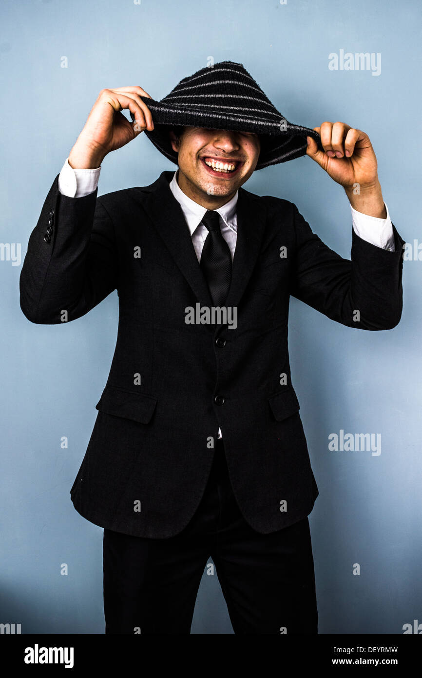 Jeune homme d'affaires est souriante de sous son bonnet de laine Banque D'Images