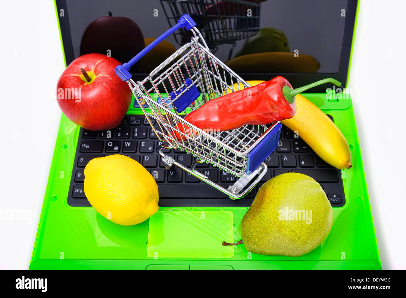 Fruit d'un ordinateur portable par panier, un service d'achat en ligne d'aliments, de Obst auf einem coffre mit Einkaufswagen Onlineshopping, von Lebens Banque D'Images