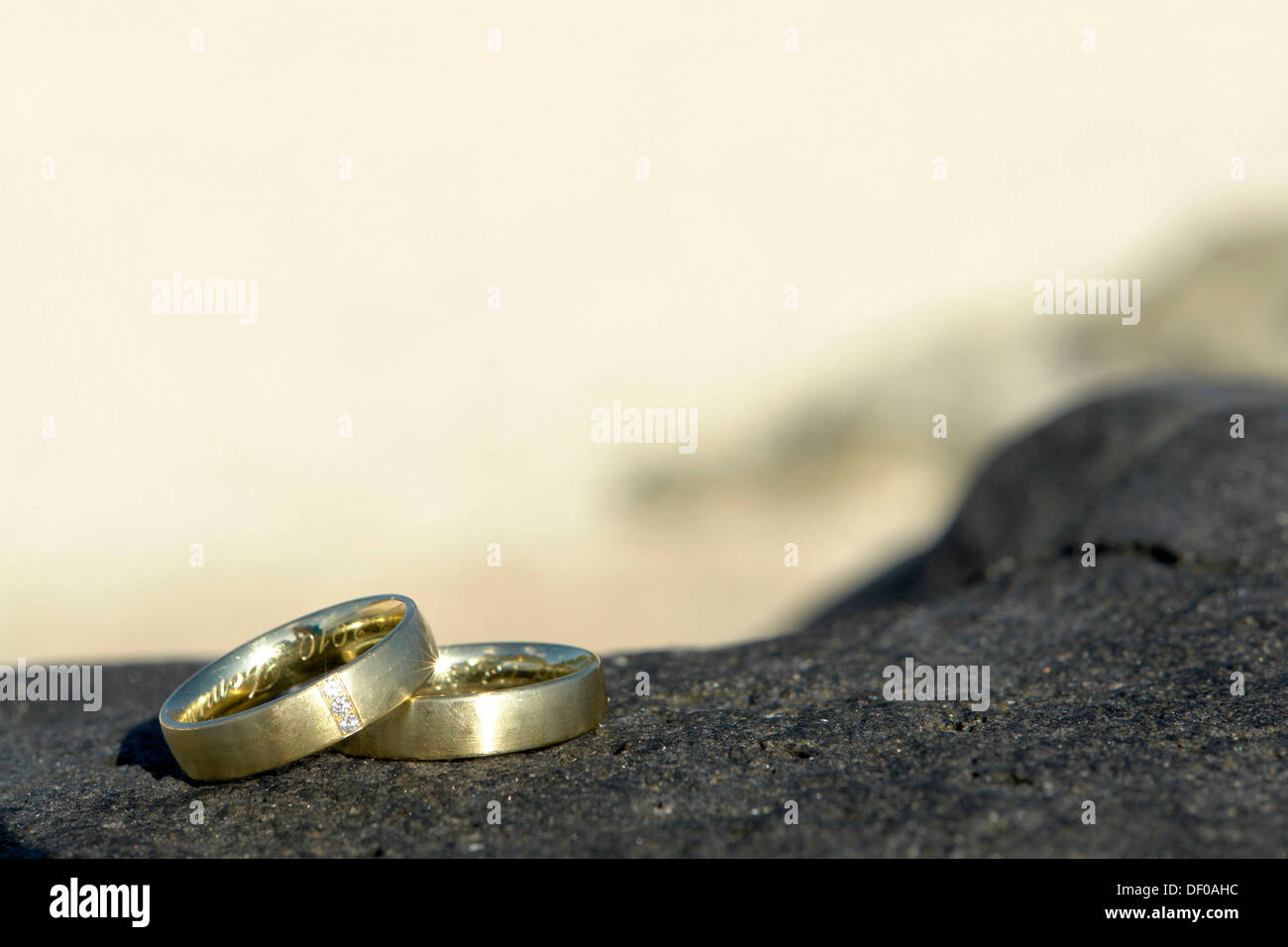 Les anneaux de mariage sur une pierre noire sur la plage de Pointe aux Piments, Ile Maurice, Afrique du Sud Banque D'Images