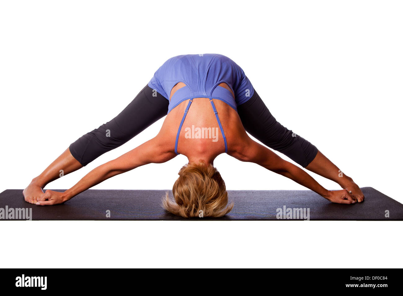 Belle femme en bonne santé faisant intense permanent inversion jambe Prasarita Padottanasana propagation yoga pose avec la tête sur le sol. Banque D'Images