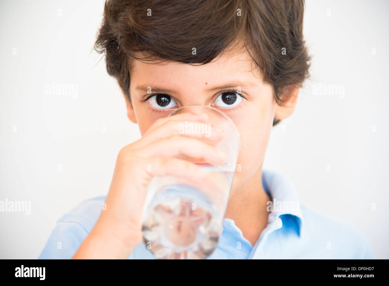 Garçon en bleu clair face close up verre d'eau potable Banque D'Images