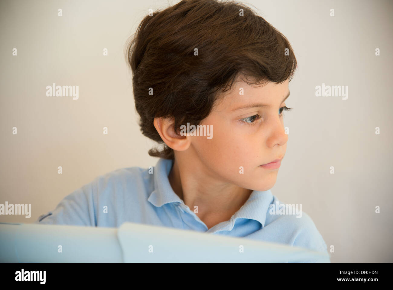 Un garçon d'âge préscolaire d'avions de papier volant en bleu clair Banque D'Images