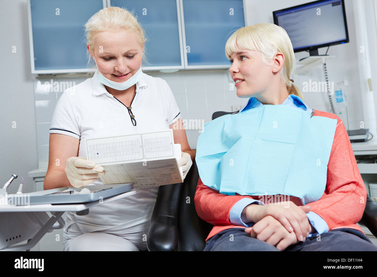 La lecture de l'enregistrement médical dentiste patient avant le traitement dentaire Banque D'Images La lecture de l'enregistrement médical dentiste patient avant le traitement dentaire Banque D'Images