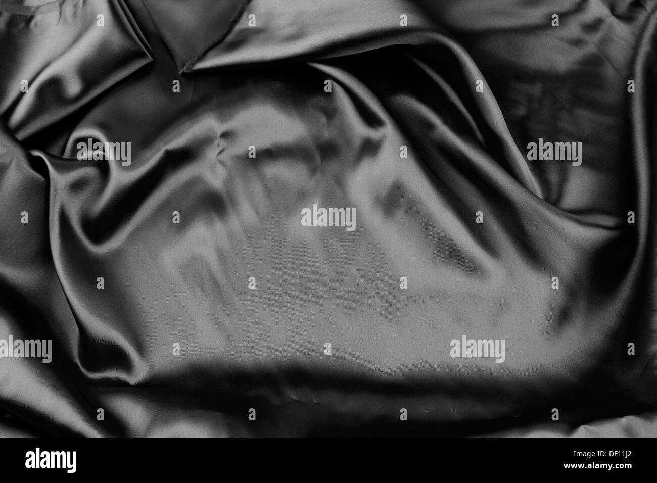 Gros plan du tissu en soie noire ondulée Banque D'Images