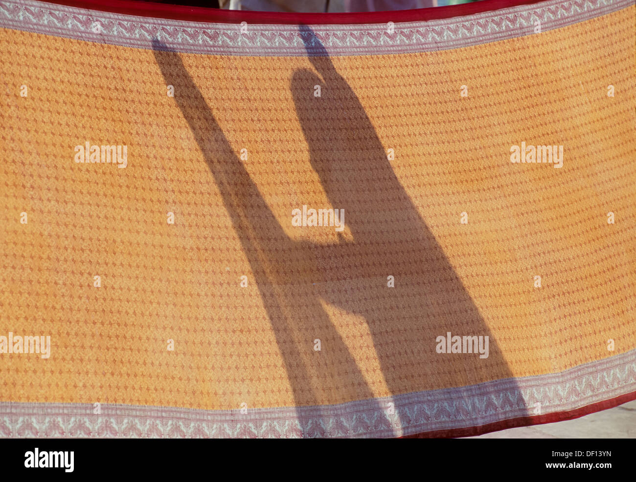 Ombre d'une femme son sari de séchage après le bain dans le Gange, Triveni Ghat, Rishikesh, Uttarakhand, Inde Banque D'Images