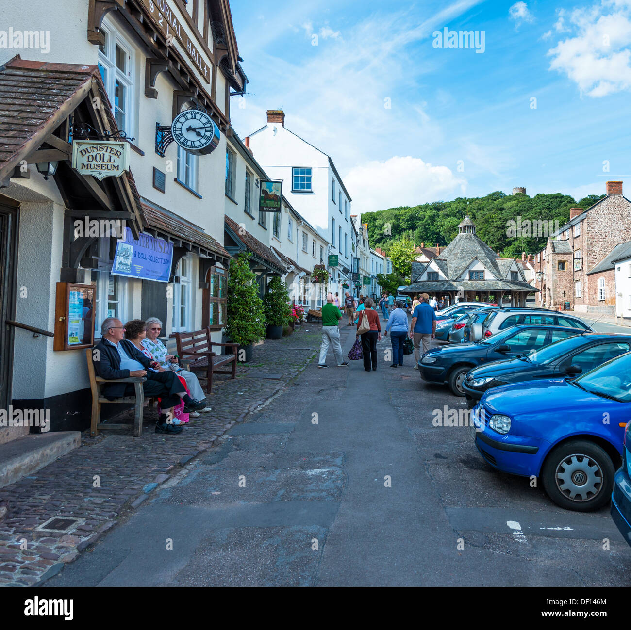 Dunster, Somerset, Angleterre, Royaume-Uni. La rue principale de Dunster montrant le marché du fil, Dunster Doll Museum et les touristes Banque D'Images