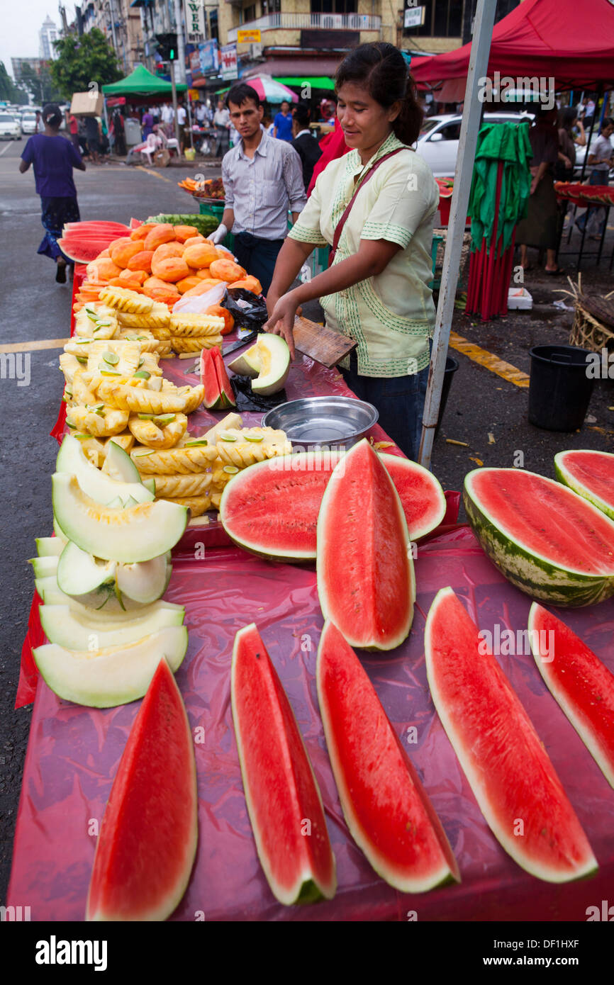 Un vendeur de fruits melon coupe à Yangon, Birmanie. Banque D'Images