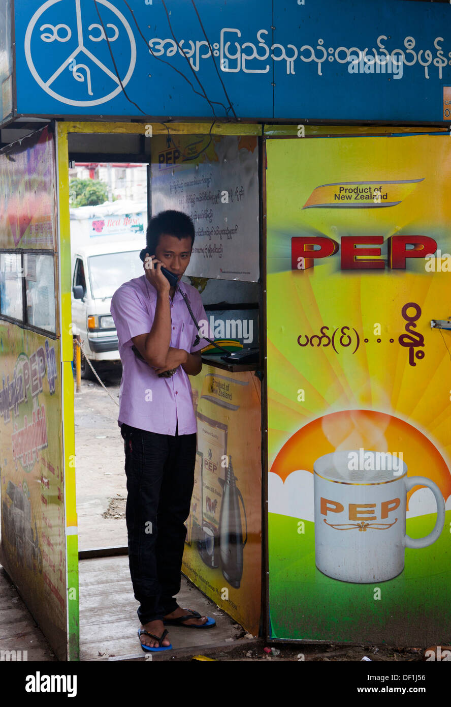 Un homme fait un appel à partir d'un téléphone shop à Yangon, Birmanie. Les téléphones cellulaires ne sont pas encore largement utilisées. Banque D'Images