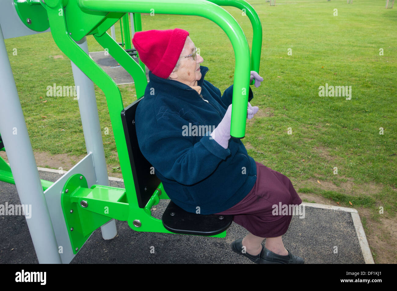 Quatre-vingt-dix ans dame sur machine d'exercice en parc public. UK Banque D'Images