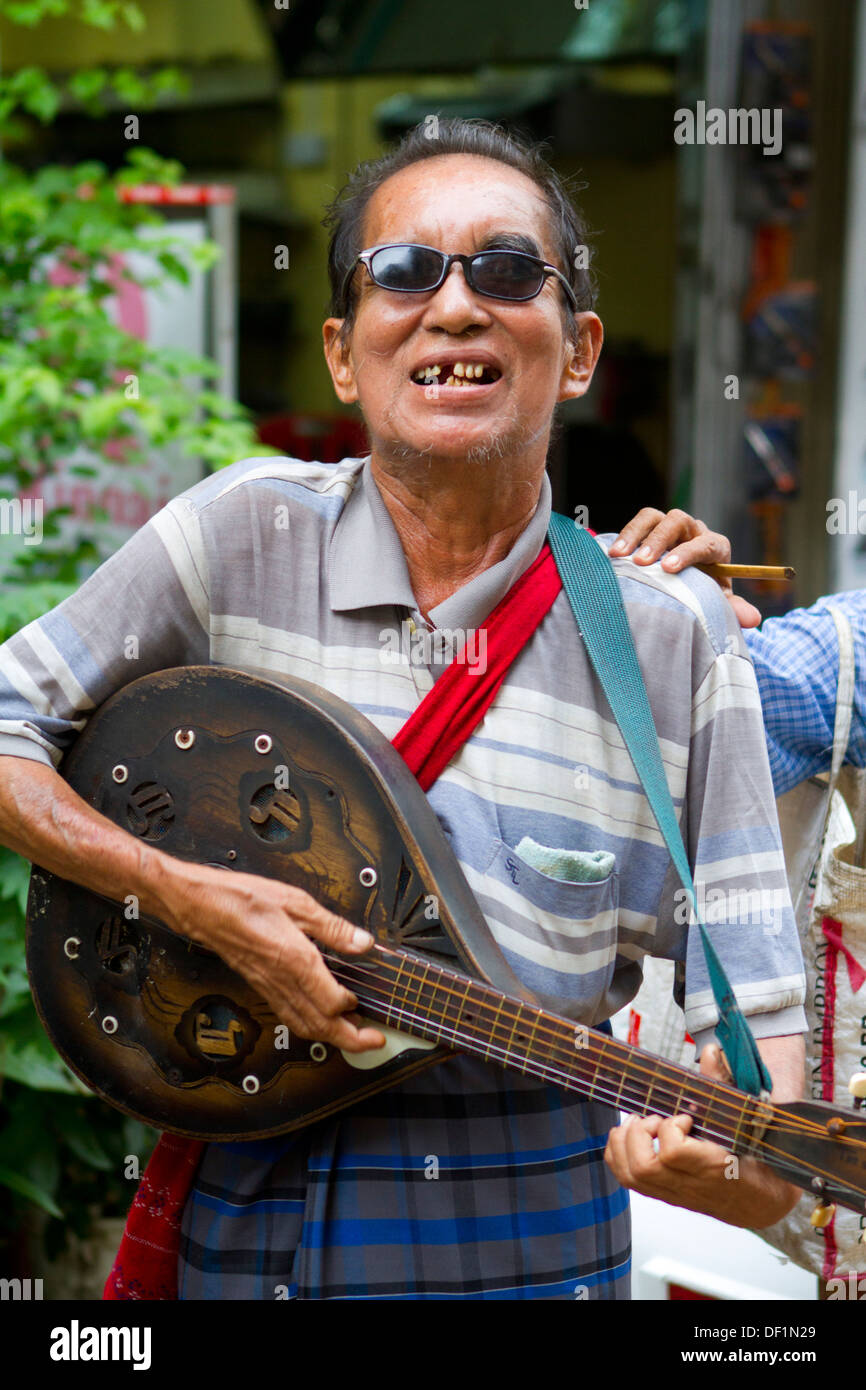 Un aveugle joue de la guitare pour de l'argent à Yangon, Birmanie. Banque D'Images