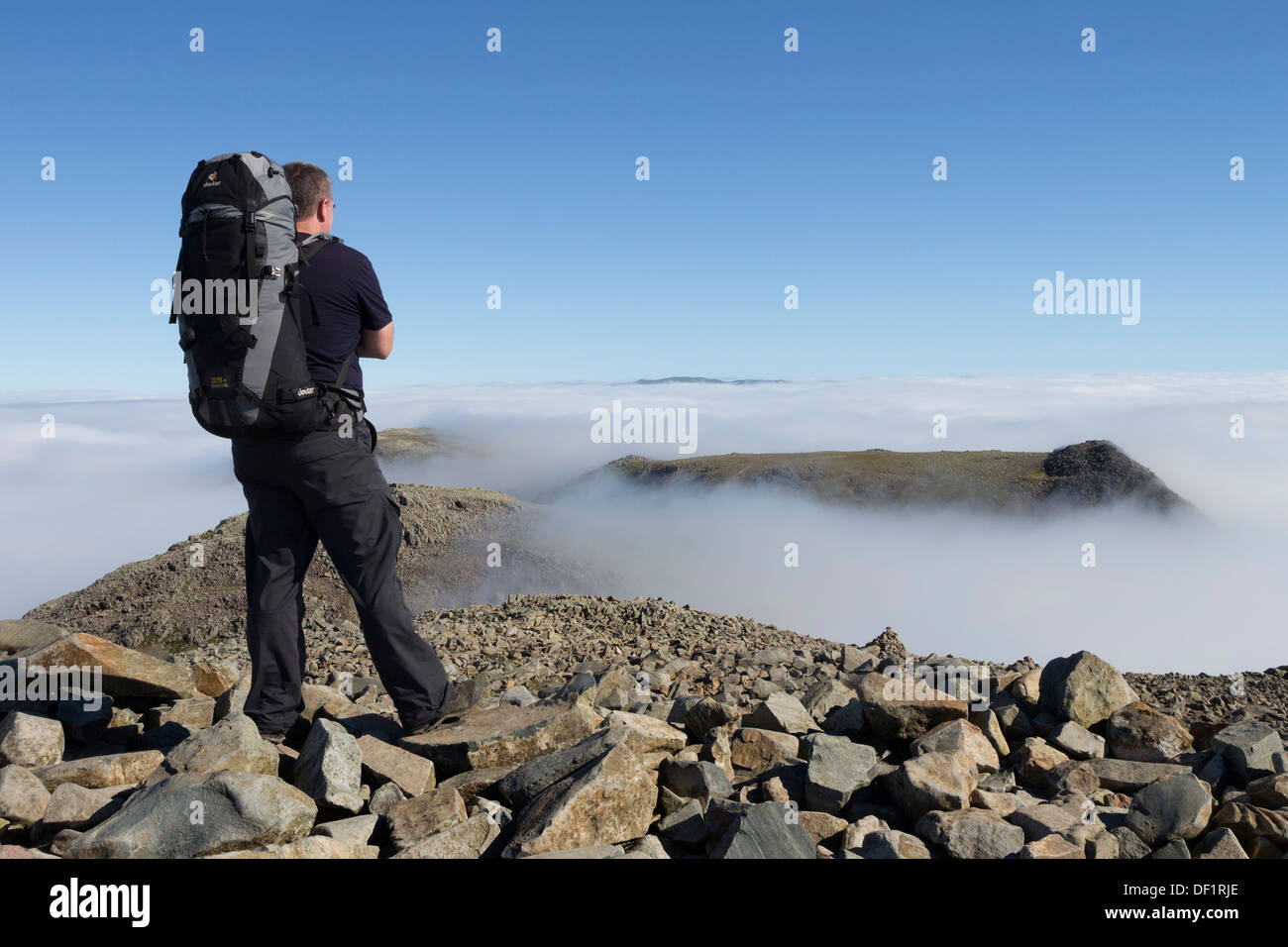 Walker sur le sommet de Scafell Pike à la plus vaste du Crag et mauvais Crag Lake District Cumbria UK Banque D'Images