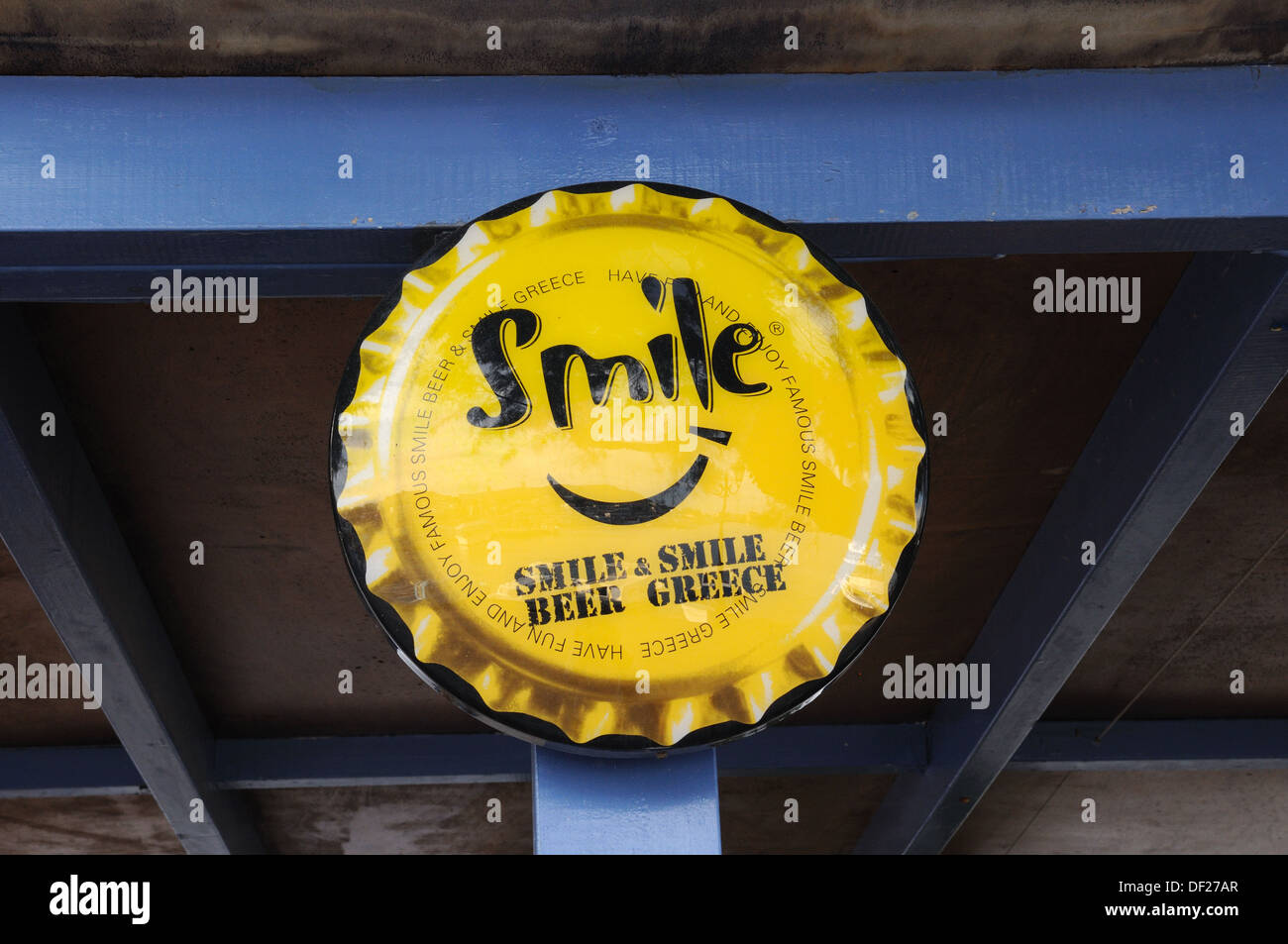 Sourire sourire bière grec publicité pour la bière dans la forme d'une bouteille haut Halki Chalki Grèce Banque D'Images