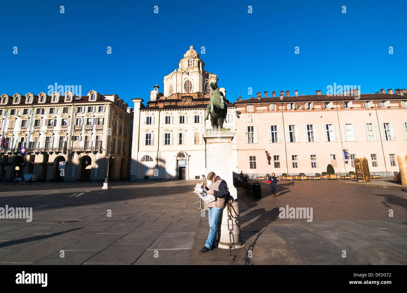 Tôt le matin dans la vieille ville de Turin. Un homme vérifie les derniers potins sportifs dans le journal. Banque D'Images