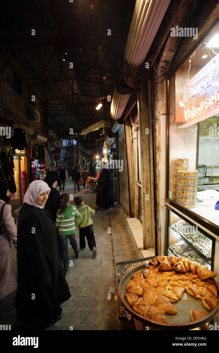 Femme en noir et des vêtements traditionnels à la voile à l'affichage d'une  boulangerie dans le souk d'Alep, Syrie, Moyen-Orient Photo Stock - Alamy