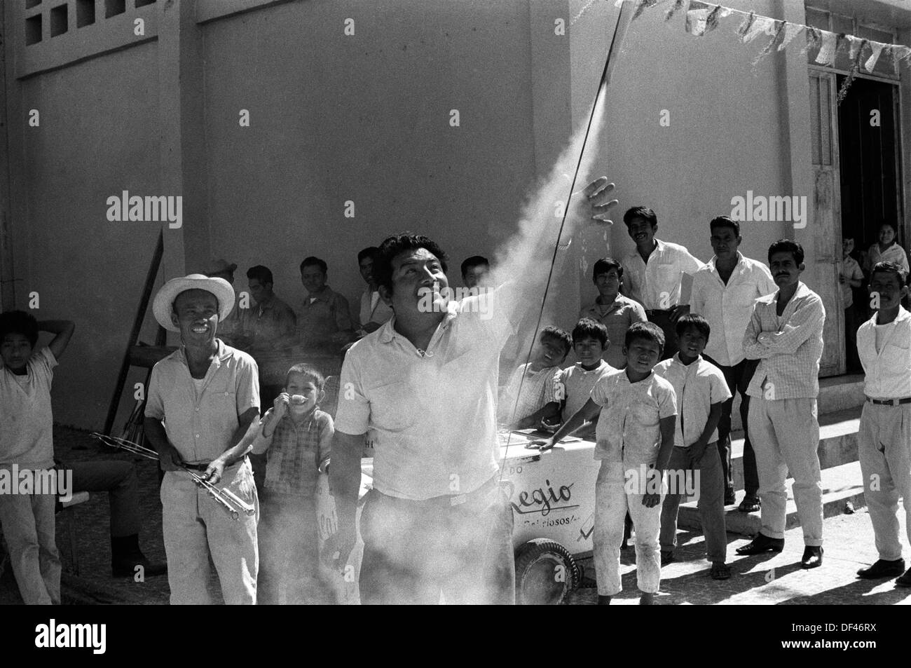 Mexique village des années 1970 fiesta Oaxaca.Man lâchant les feux d'artifice tenus à la main. Foule de gens se tiennent autour pour regarder. 1973 HOMER SYKES Banque D'Images