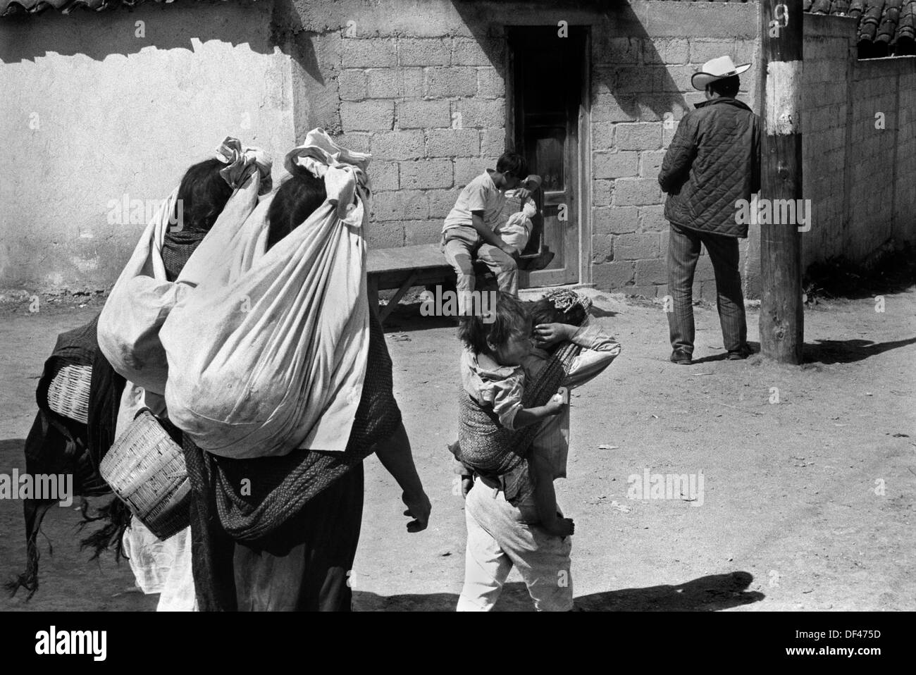 San Cristóbal de las Casas, Mexique. Les années 1970, femme et enfants autochtones qui vont au marché quotidien. Vue arrière ils transportent des marchandises à vendre dans des sacs de feuilles tenus de leur tête. État mexicain du Chiapas. 1973 HOMER SYKES Banque D'Images