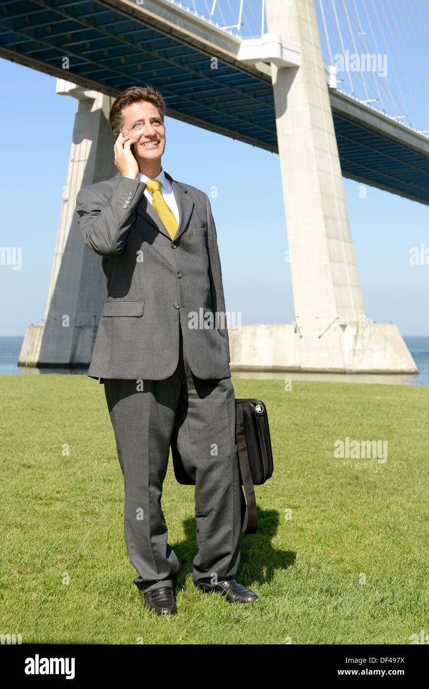 Businessman with cellphone outdoors Banque D'Images