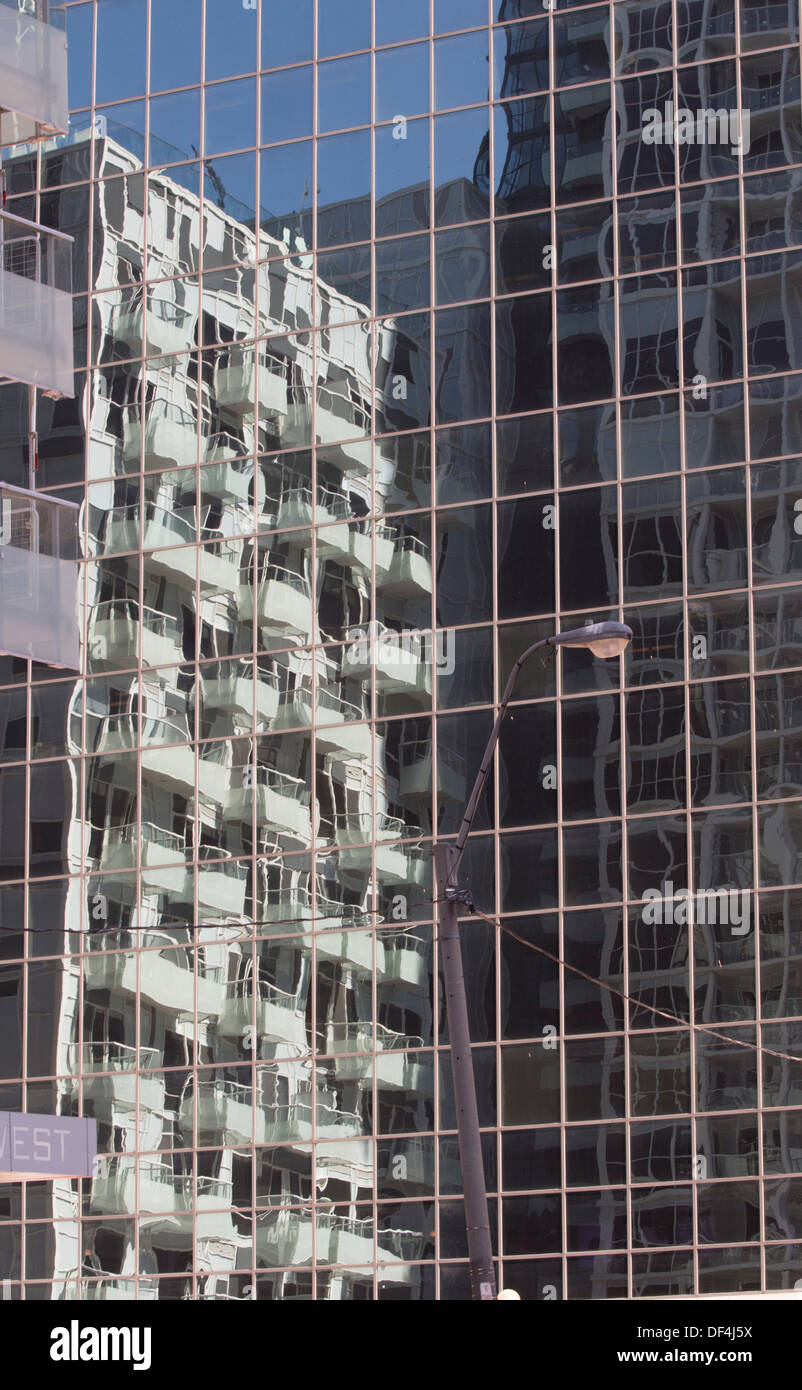 Reflet d'un immeuble à appartements dans le verre d'une tour d'affaires adjacent. Banque D'Images
