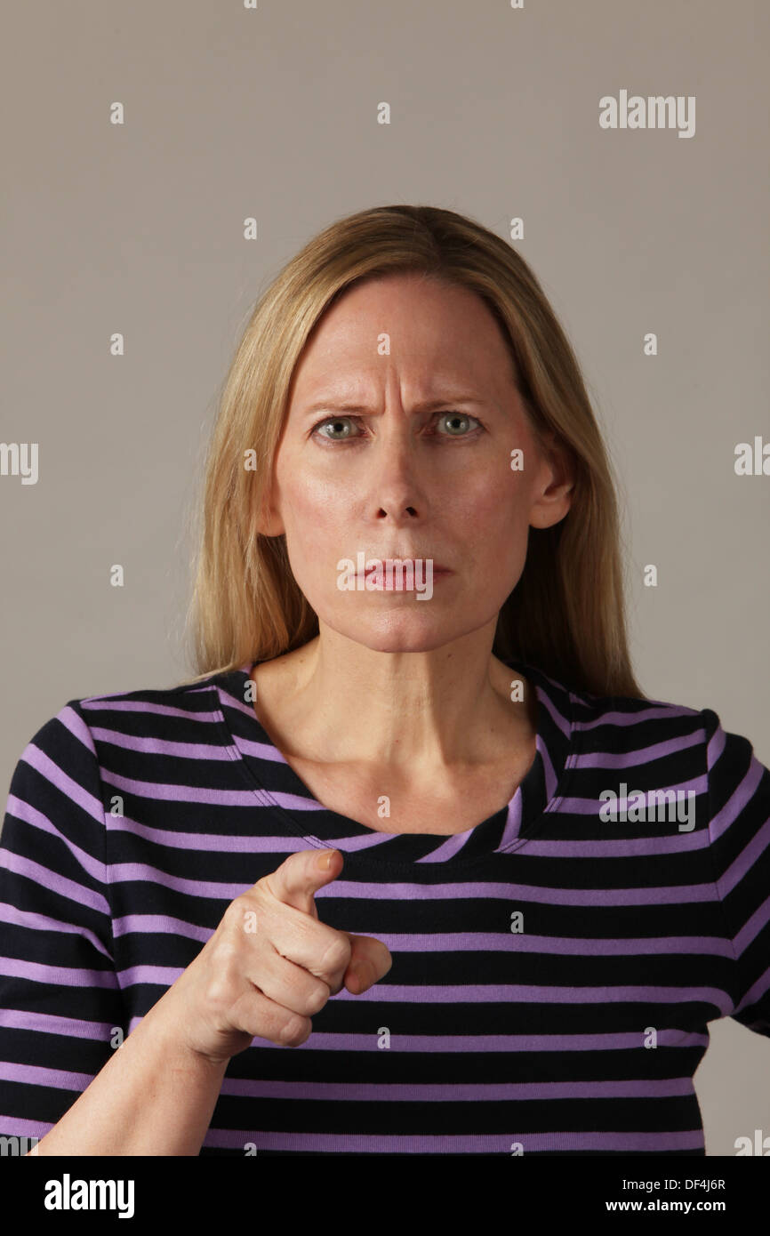 Sévère et sérieuse belle femme d'âge moyen et de pointage, USA Banque D'Images