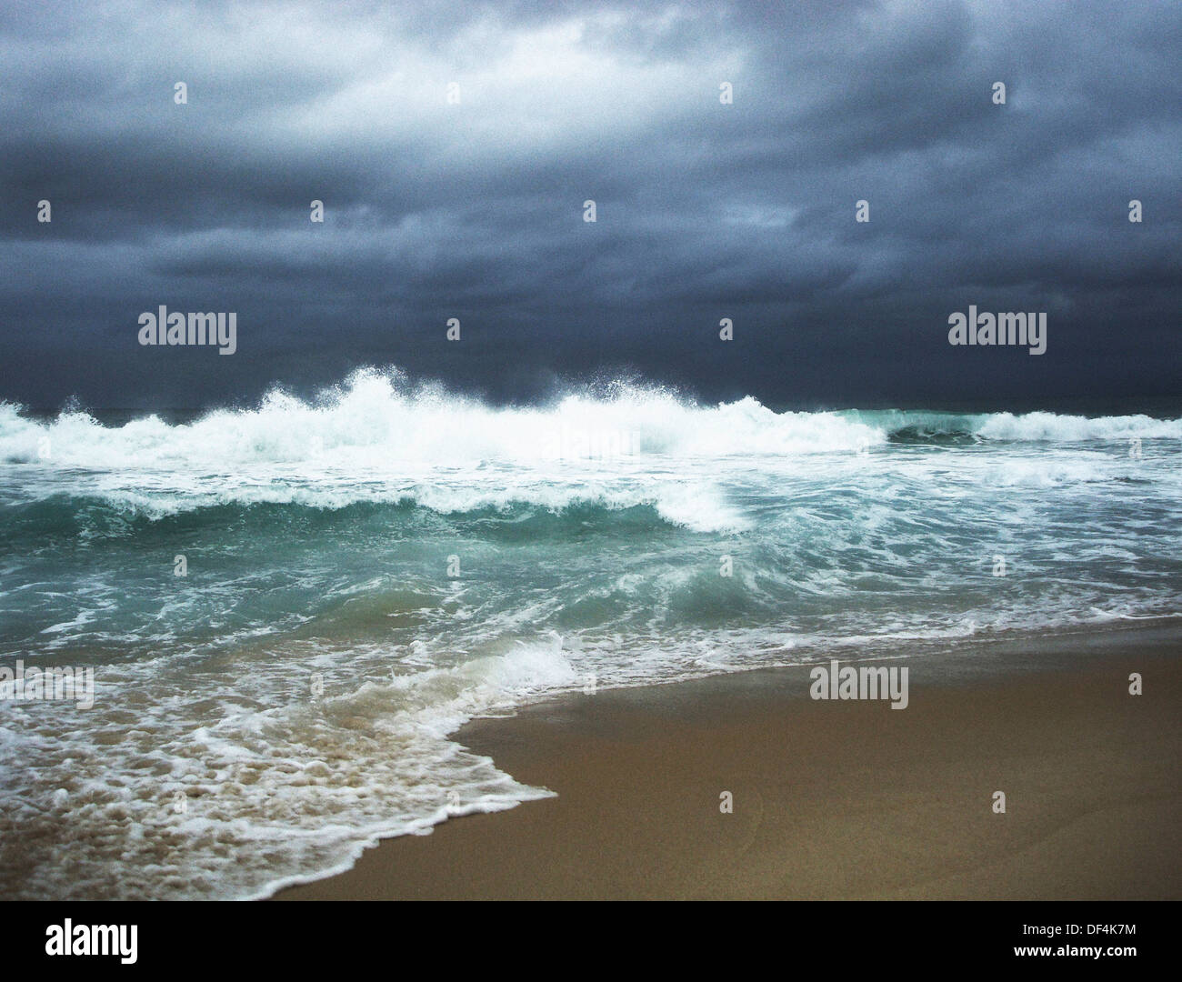 Le fracas des vagues et orageuse avec un ciel gris menaçant Glouds Banque D'Images