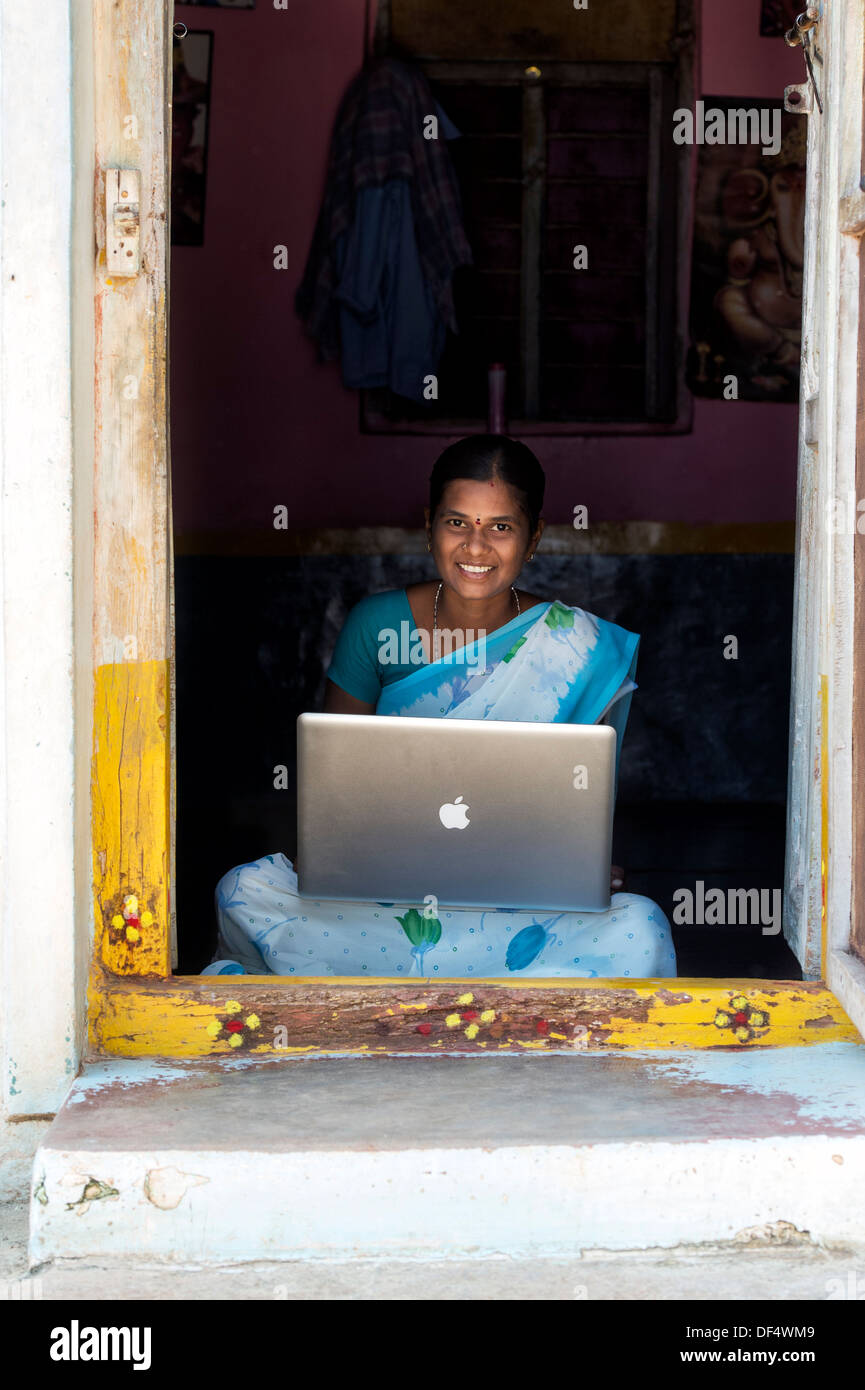 Les femmes du village de l'Inde rurale à la recherche à un portable Apple dans sa maison de la porte. L'Andhra Pradesh, Inde Banque D'Images