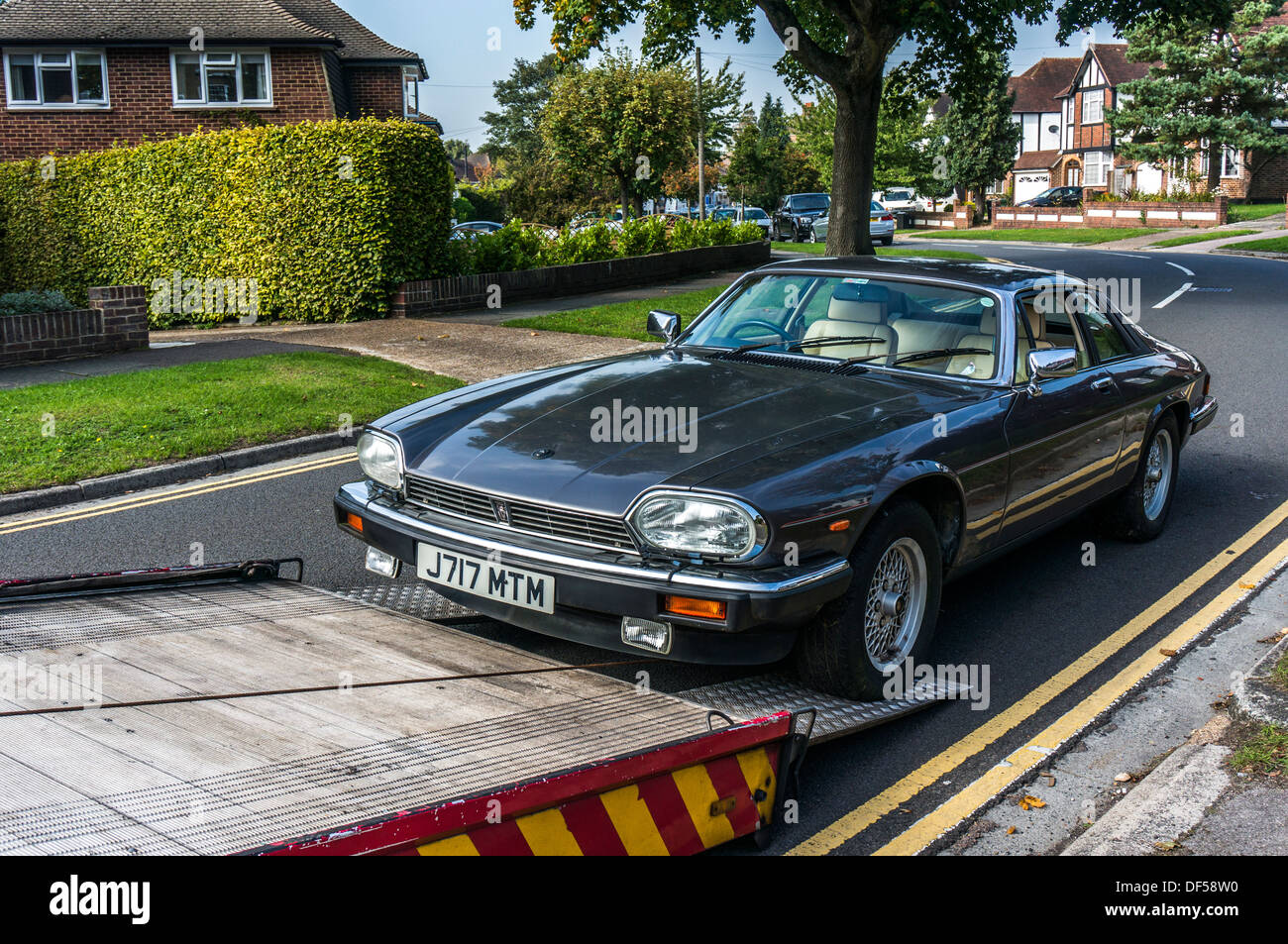 Une Jaguar XJS étant ramené sur un véhicule de récupération, dans and Banstead, Surrey, Angleterre. Banque D'Images