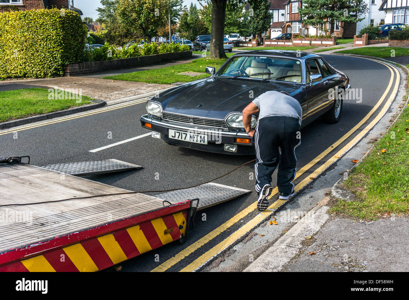 Sécurisation d'un homme Jaguar XJS prêt à être ramené sur son véhicule de récupération, dans and Banstead, Surrey, Angleterre. Banque D'Images