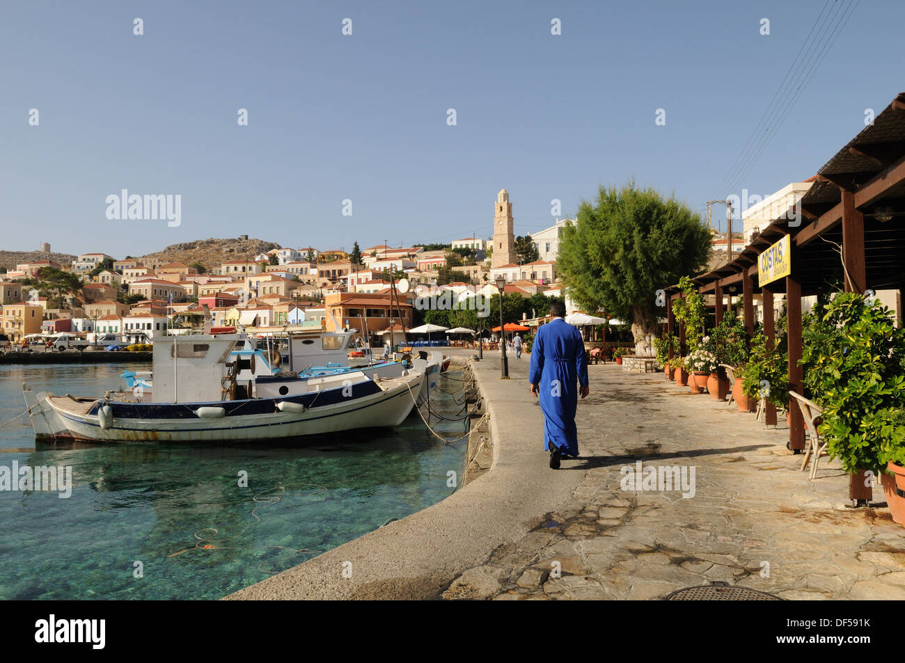 Prêtre grec orthodoxe de Halki Chalki marche le long harbour îles grecques du Dodécanèse Grèce Banque D'Images