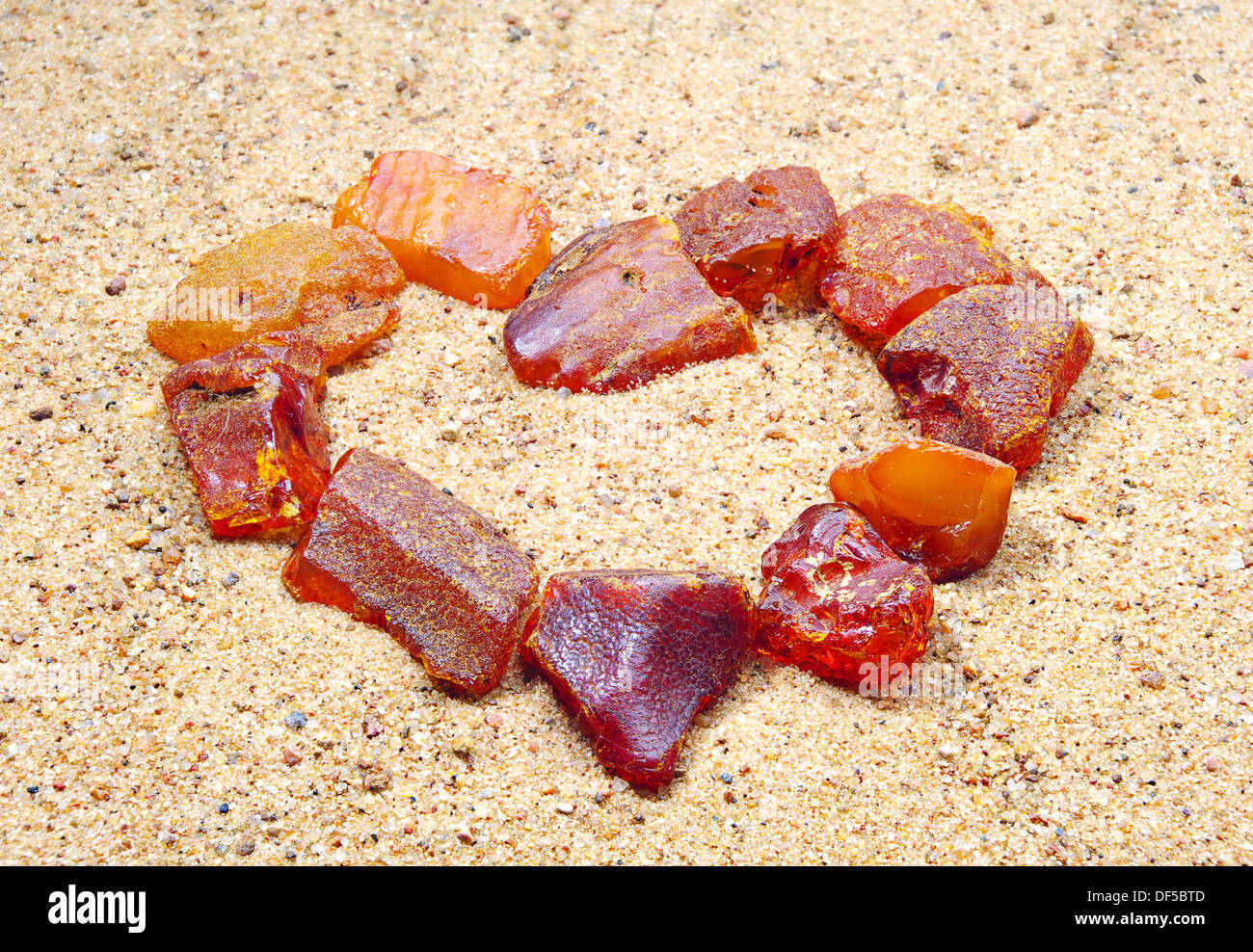 L'ambre dans la forme d'un coeur dans le sable Banque D'Images