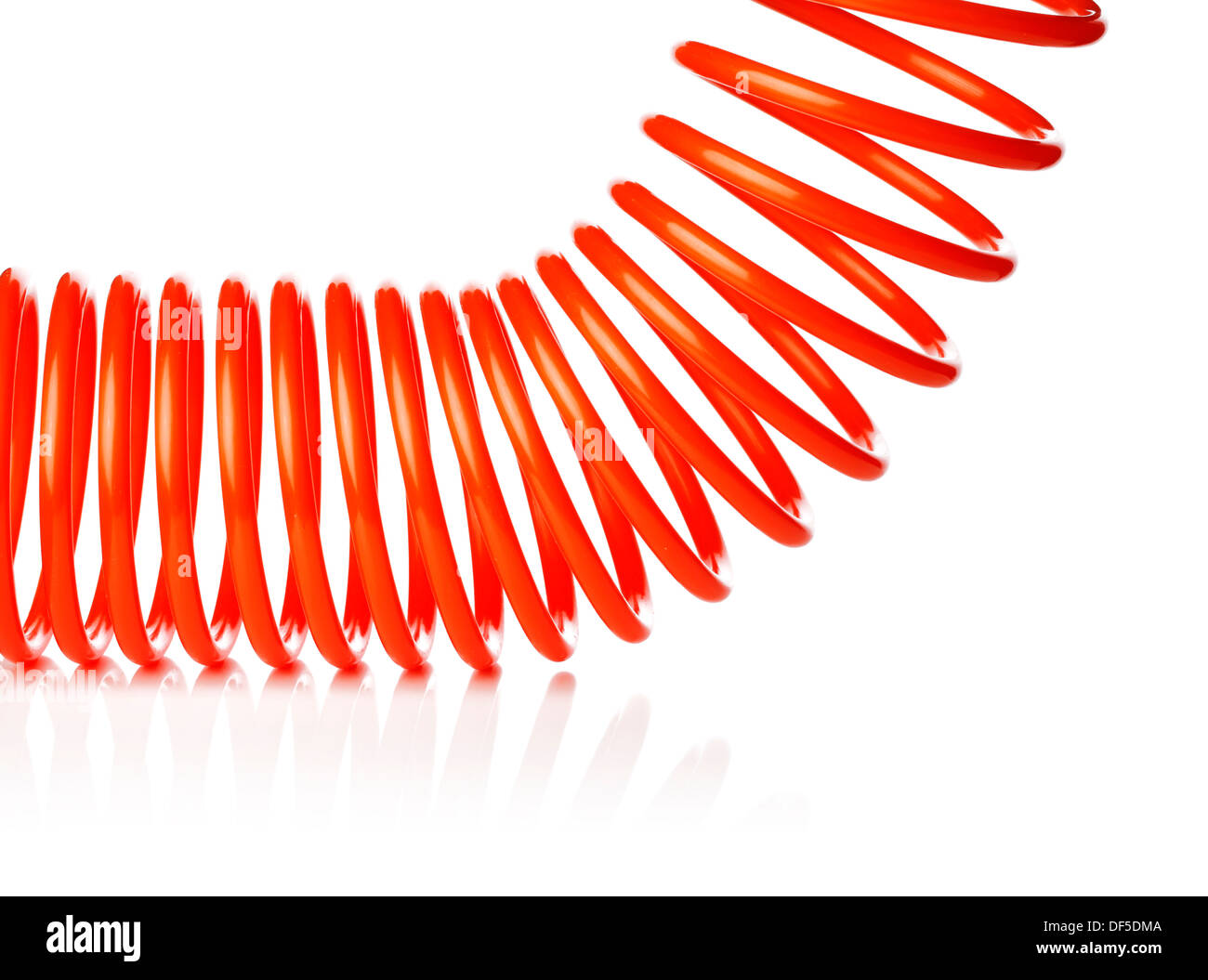 Spirale rouge fine orange flexible d'air utilisé pour outils pneumatiques. Isolé sur blanc avec reflet naturel. Banque D'Images