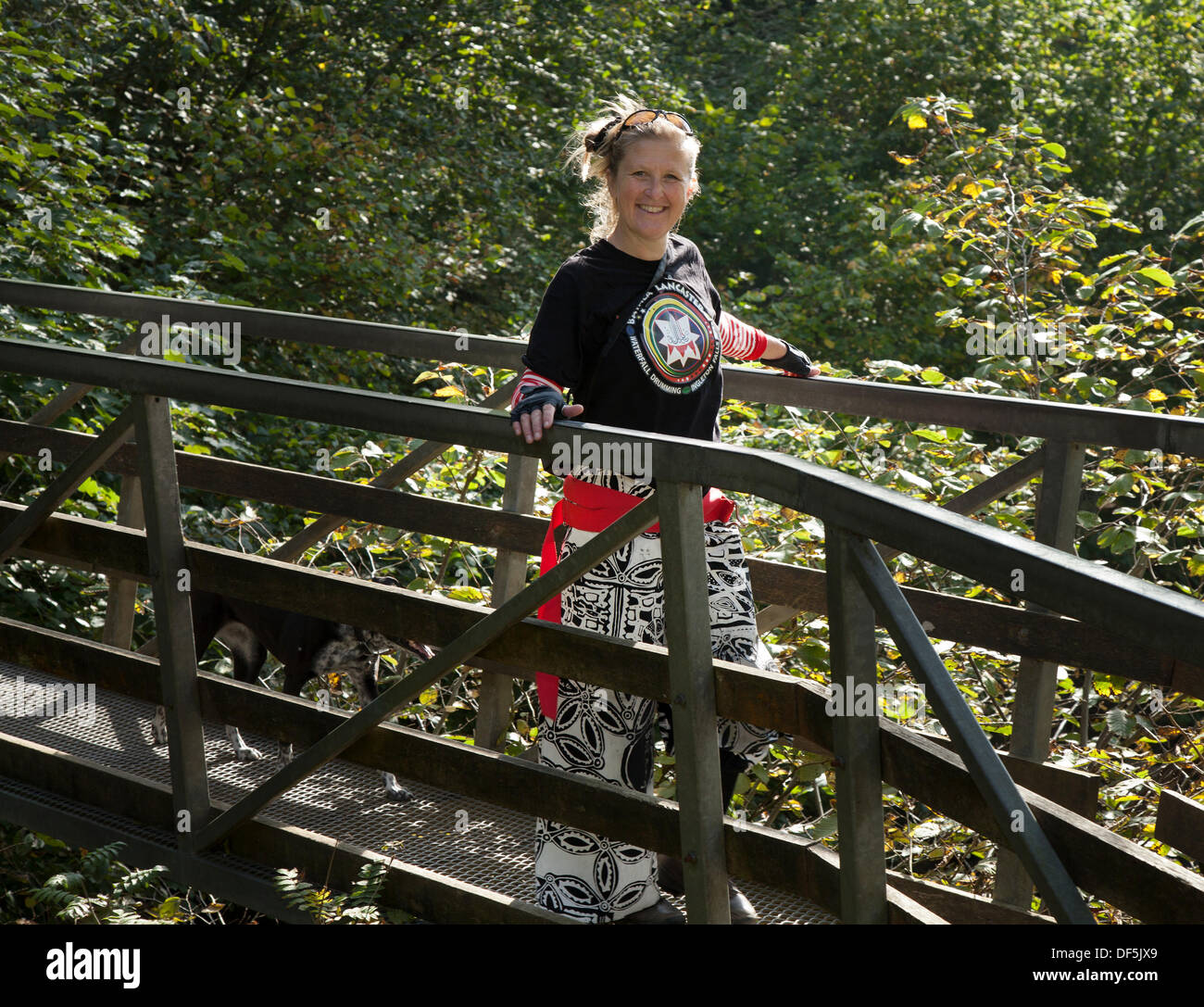 Ngleton UK. 28 Septembre, 2103. Les membres de Batala Samba Band traversant la passerelle en bois sur la route de Ingleton Falls Cascade pour leur événement de percussion. La musique de l'eau a pris une signification différente pour les membres de la bande 'percussions samba Batala Lancaster' le samedi. Ils ont joué leurs instruments tout en se tenant dans le cours d'eau ci-dessous Thornton Force - sur la chute d''Ingleton à pied. L'événement de bienfaisance était de faire un vrai splash pour la fondation d'éducation Longstaffe, Bentham. Banque D'Images